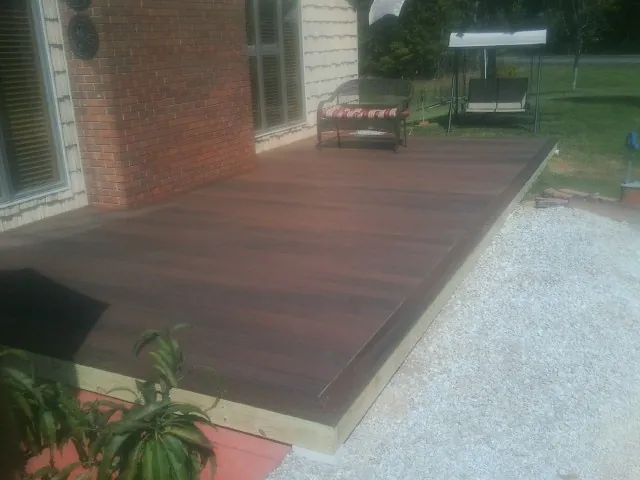 Freshly stained wood deck built against a brick home in Salem